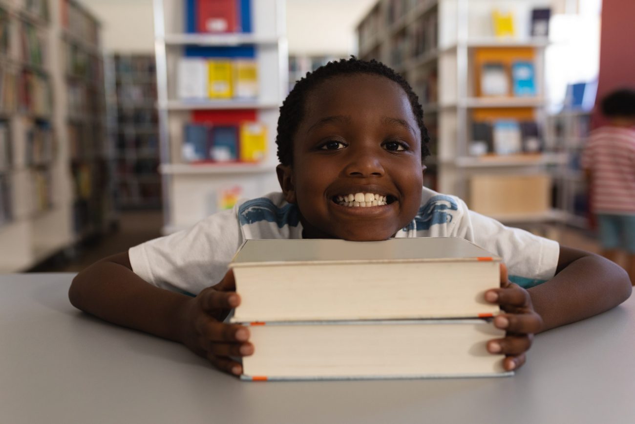 child with chin on books